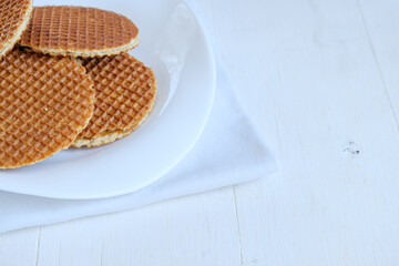 Dutch waffles on a white plate, on a white background, horizontal shot