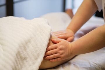 Obraz na płótnie Canvas Body care concept. Special anticellulite treatment. Masseur makes anticellulite massage young woman in spa salon. Close up view