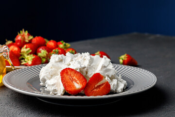 Cream cheese and fresh strawberries on black background