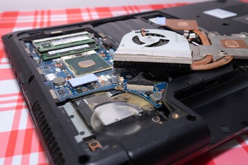 Obraz premium A disassembled laptop and a screwdriver on the table.