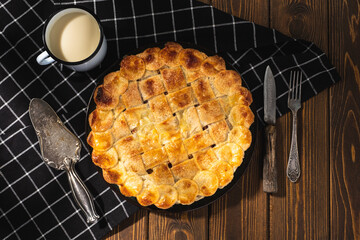 apple pie with milk on a wooden background. Rustic style.