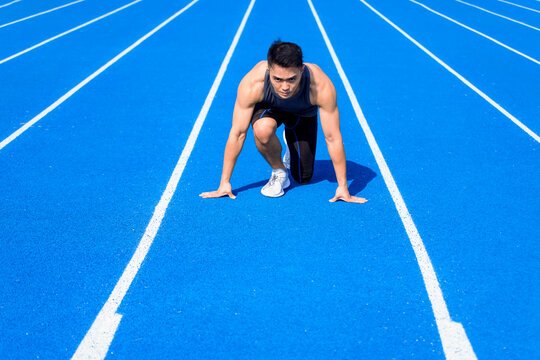 Male  athlete on  race track is ready to run