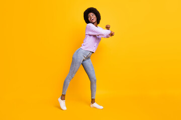 Fototapeta na wymiar Full body portrait of positive dark skin person partying look empty space toothy smile isolated on yellow color background