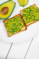 Tasty avocado sandwiches on table