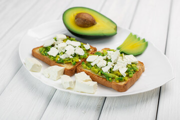 Tasty avocado sandwiches on table