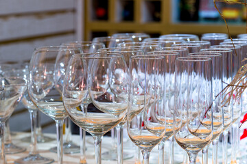 set of empty glass goblets for champagne, wine, water stand in row on table