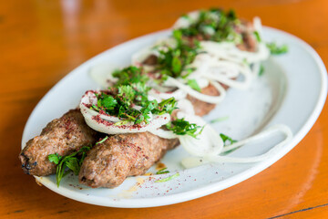 Grilled kebabs on the plate and fresh vegetables