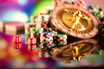Fototapeta na wymiar Casino theme. Roulette wheel, poker chips and dice on colorful bokeh background.