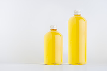 Set of two plastic tall and low bottles with orange drink, cooking oil or cosmetic produce, silver cap mockup on white background, template, copy space.