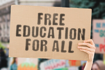 The phrase " Free education for all " on a banner in men's hand with blurred background. Study. Knowledge. Lessons. School. University. Preschool. Protest