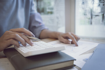 Financial businesswoman calculating corporate income tax data And analyzing charts of financial stocks that are in good condition with growth and progress, Investment in finance.