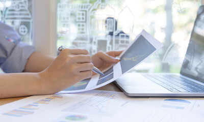 Financial businesswomen analyze the graph of the company's performance to create profits and growth, Market research reports and income statistics, Financial and Accounting concept.