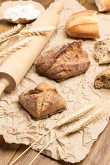 Pieces of bread, rolling pin and sprigs of wheat on paper