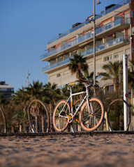 Fototapeta premium Bicycle with orange wheels parcked at the beach during sunrise
