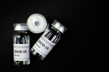 Coronavirus vaccine bottle flipped isolated on black background. Covid-19 situation disease pharmacy in laboratory and drug to cure people.  Healthcare and Medical concept. Development of research.