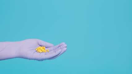 Sedative pills, valerian in hand with blue glove