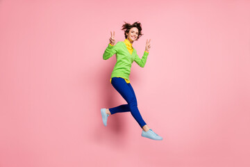 Fototapeta na wymiar Full body photo of young cheerful girl jump up excited show peace cool greetings v-sign isolated over pink color background