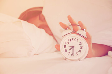 Hand reaching out for alarm clock 