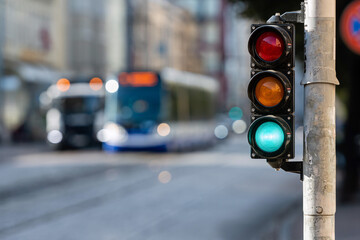 view of city traffic with traffic lights, in the foreground a traffic light with a green light