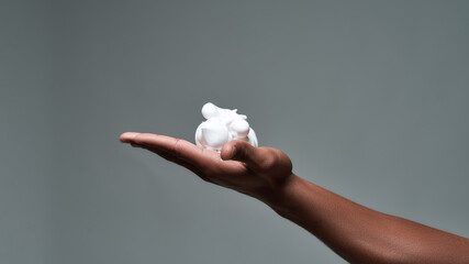 Close up of hand of young african american man holding shaving foam, ready to shave isolated over gray background - Powered by Adobe