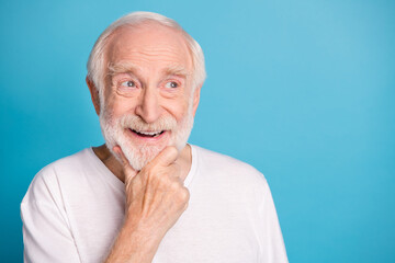 Photo of cheerful aged guy arm on chin look empty space thinking isolated on pastel blue color background