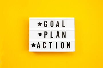 Goal, Plan, Action text on light box on yellow background.