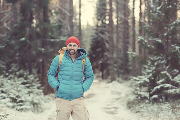 winter landscape forest backpack man / traveler in modern winter clothes in the forest, traveling in the mountains  europe, switzerland winter