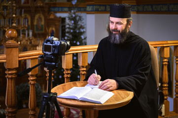 . Priest online. An Orthodox priest is recording a video for his blog. Preaching during a pandemic.