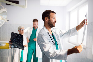 Doctors examining an x-ray report in hospital to make diagnosis