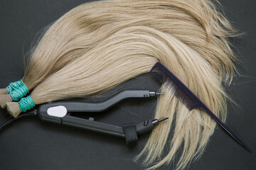 a large strand of hair with a thin comb-scissors device for encapsulating . 