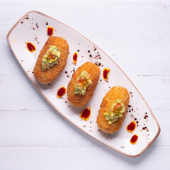 Traditional spanish croquettes tapas with avocado. Veggie tapa.