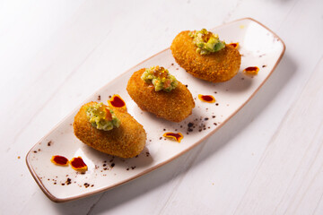 Traditional spanish croquettes tapas with avocado. Veggie tapa.