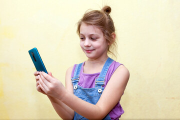 Blond girl 8 years old taking  selfie on  phone.