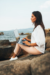 Freelance concept. A freelancer girl with a laptop on her lap works out of the office