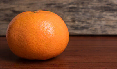 Whole orange on a wooden table.