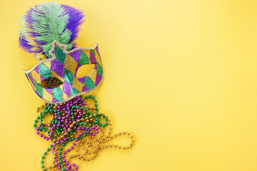 Mardi gras or carnival mask with beads on yellow background. Venetian mask.