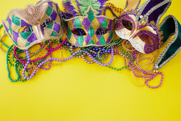 Mardi gras or carnival mask with beads on yellow background. Venetian mask. - obrazy, fototapety, plakaty