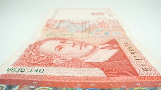 A closer look of the face image on the 5 Bulgarian lev paper bill on the table