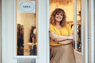 Successful fashion store owner standing at entrance door