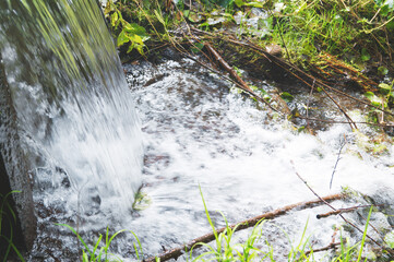 small natural waterfall in the forest in spring summer autumn horizontal image