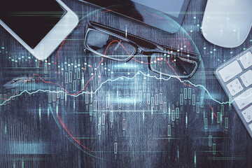 Multi exposure of forex graph hologram over desktop with phone. Top view. Mobile trade platform...