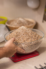 man weighs malt for brewing beer on scale