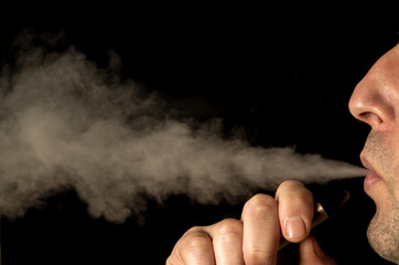 Close up on a man exhaling vapor from an electronic cigarette