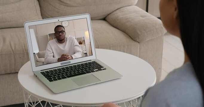Woman video chatting with male friend using laptop at office