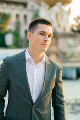 Portrait of an attractive male groom on a sunset background. Male image for the wedding.