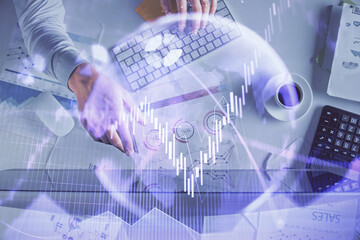 Multi exposure of man's hands typing over computer keyboard and forex graph hologram drawing. Top view. Financial markets concept.