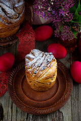 Easter cake kraffin. Kraffins with raisins, candied fruits and poppy seeds, sprinkled with powdered sugar. Close-up of homemade cake. Cruffin. Red colored eggs.