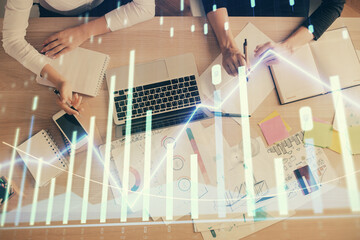 Double exposure of woman hands working on computer and forex graph hologram drawing. Top View....