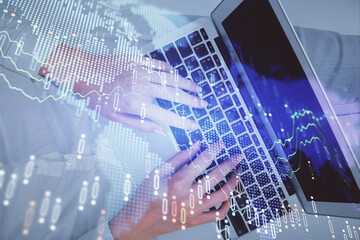 Double exposure of woman hands working on computer and forex chart hologram drawing. Top View. Financial analysis concept.