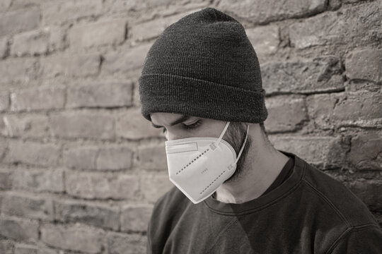 Man wearing FFP2 mask, brick wall, urban